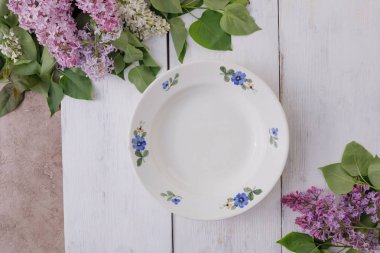 Beyaz boyalı bir arka plan üzerinde bir tabak ve çiçek bir dekor 