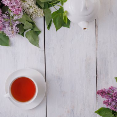 Tea set and flower decor against a background of white-painted w