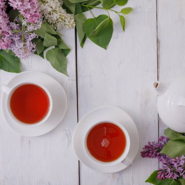 Tea set and flower decor against a background of white-painted w