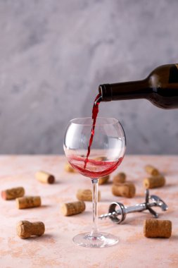 Kırmızı şarap bir bardağa dökülür. Şarap çıtası kavramı. Metninizin altına yerleştirin.
