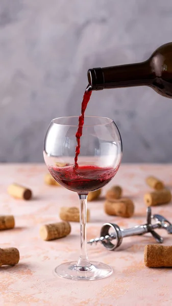 Red wine is poured into a glass. The concept of winemaking. Plac
