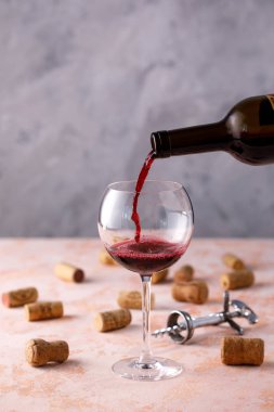 Kırmızı şarap bir bardağa dökülür. Şarap yapımı kavramı. Plac