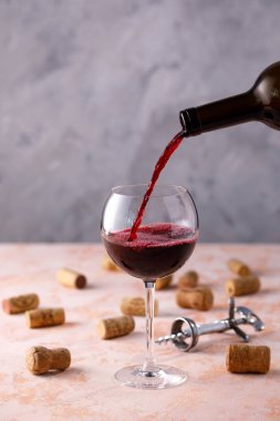 Kırmızı şarap bir bardağa dökülür. Şarap yapımı kavramı. Plac