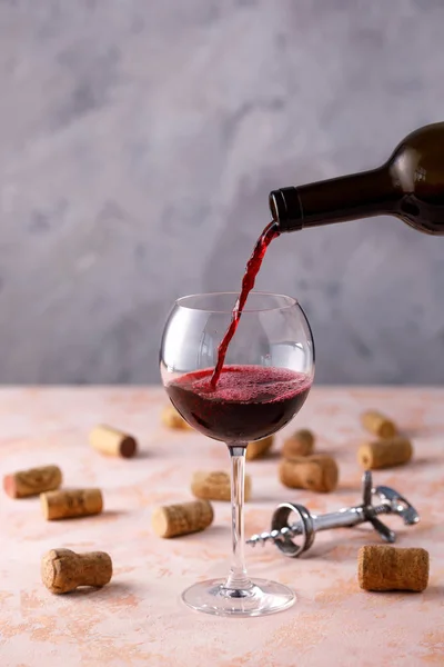 Red wine is poured into a glass. The concept of winemaking. Plac