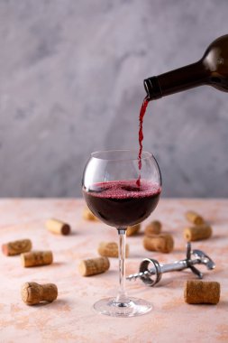 Kırmızı şarap bir bardağa dökülür. Şarap yapımı kavramı. Plac