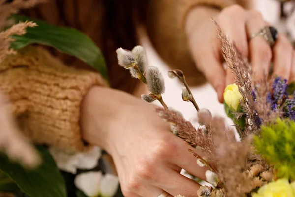 Mão feminina compondo uma composição de flores de urze e ramos de salgueiro. O conceito de ternura . — Fotografia de Stock