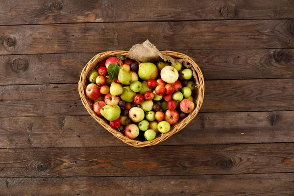 Cesto pieno di mele mature e pere su fondo ligneo. Vista dall'alto. Piatto. Ricevuto. Concetto di raccolta . — Foto Stock