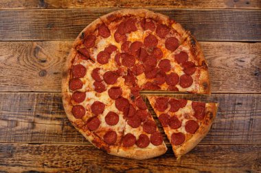 Ahşap masaüzerinde geleneksel piperoni pizza. Close. Lezzetli gıda kavramı.