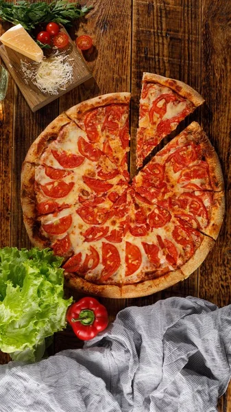 Pizza Margarita on a wooden table. Still life. Look up.