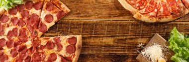 Pizza Pepperoni ve Margarita tahta bir masada. Malzemelerle natürmort. Üst te. Kopyalama alanı.