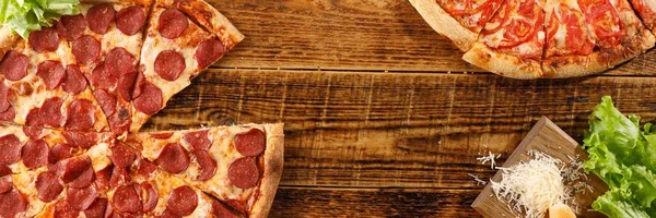 Pizza Pepperoni ve Margarita tahta bir masada. Malzemelerle natürmort. Üst te. Kopyalama alanı.