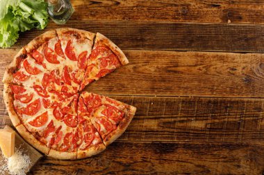 Pizza Margarita tahta bir masada. Malzemelerle natürmort.