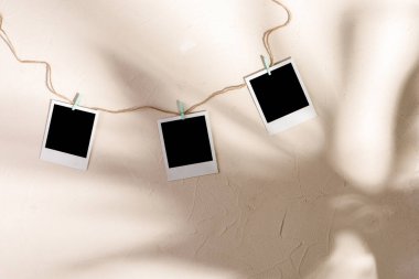 Boş fotoğraflar desen arka planında mandallarla asılı..