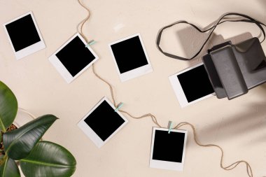 Boş fotoğraflar ve arka planda mandalları olan bir kamera. Anıları koruma kavramı.