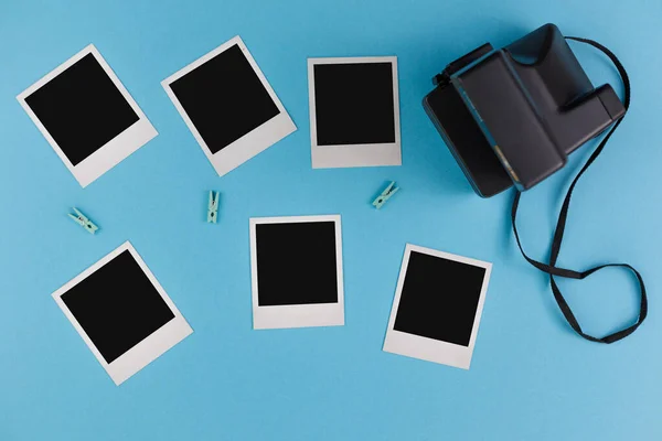 Instant photo frames and camera on a blue background. Concept of preservation of memories. Flat lay. — Stock Photo, Image