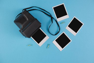 Mavi arka planda anlık fotoğraf çerçeveleri ve kamera. Anıların korunması kavramı. Düz yatıyordu.