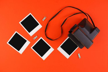 Kırmızı arkaplanda anlık fotoğraf çerçeveleri ve kamera. Anıların korunması kavramı. Düz yatıyordu.