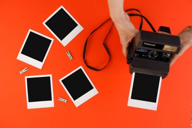 Kırmızı arkaplanda anlık fotoğraf çerçeveleri ve kamera. Anıların korunması kavramı. Düz yatıyordu.