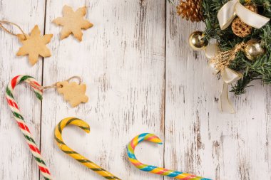 Yılbaşı karamel kamışları ve kurabiyeler eski beyaz ahşap arka planda. Mutlu yıllar, Noel süslemelerinin kompozisyonu. Tatil kavramı.