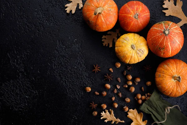 Höstens ram gjord av pumpor, trädblad, hasselnötter på svart bakgrund. Höst, höst, tacksägelse koncept. Platt läggning, kopieringsutrymme. — Stockfoto