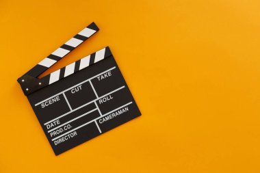 Film yapma konsepti. Film alkışlama tahtası. Sinema film alkışlarıyla başlar. Üst Manzara. Uzayı kopyala Mesajın için yer aç. Sarı arkaplan.