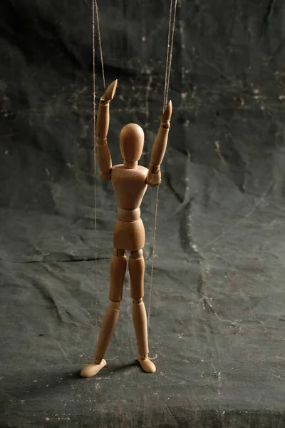 Puppet in the hands of puppeteer walks on isolated, background. Object on a texture background.