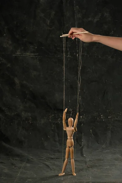 Puppet in the hands of puppeteer walks on isolated, background. Object on a texture background.