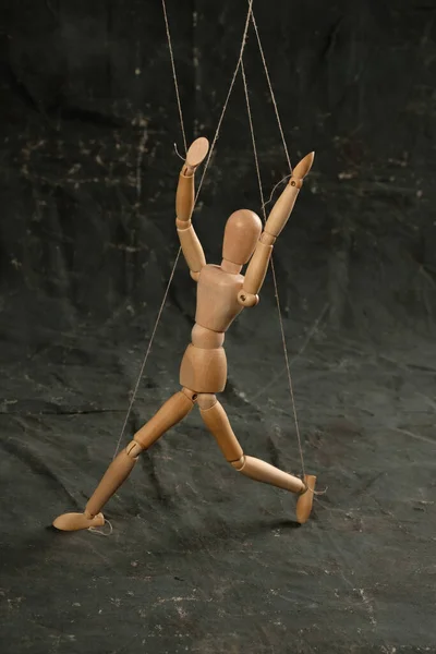 Puppet in the hands of puppeteer walks on isolated, background. Object on a texture background.