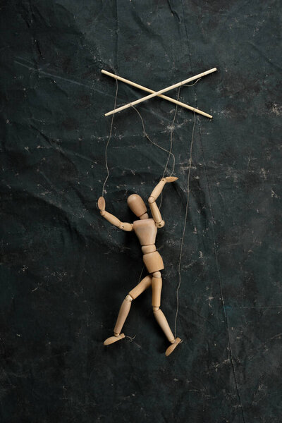 Марионетка в руках кукловода ходит по изолированному фону. Объект на текстурном фоне
.