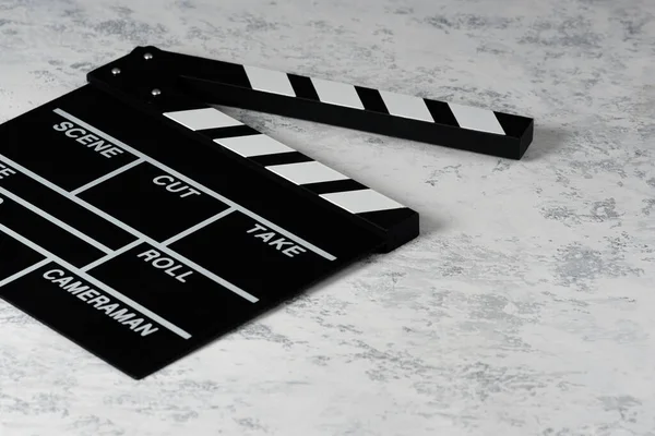 Clapper board with popcorn. Movie concept. Clapperboard on a textural background. Close-up.