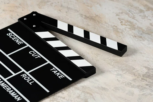 Clapper board with popcorn. Movie concept. Clapperboard on a textural background. Close-up.