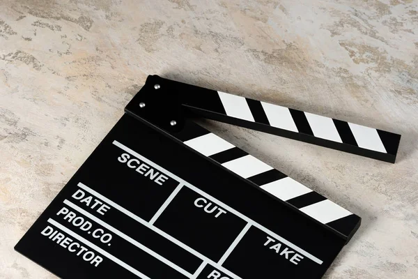 Clapper board with popcorn. Movie concept. Clapperboard on a textural background. Close-up.