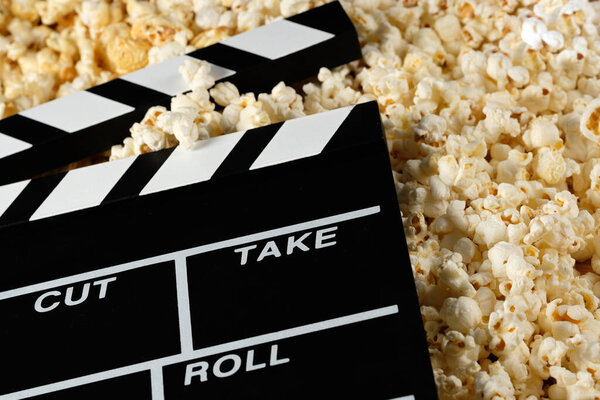 Доска с попкорном. Концепция фильма. Попкорн крекер на заднем плане. Крупный план
.