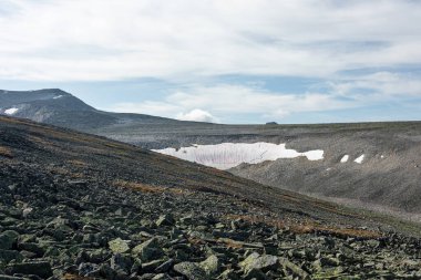 Dağlardaki açık hava aktiviteleri. Geçitte karlı bir tarlası olan, dağın yamacında kar bulunan minimalist dağ manzarası. Karlı tepe. Karlı yamacın atmosferik görüntüsü. Görkemli doğa..