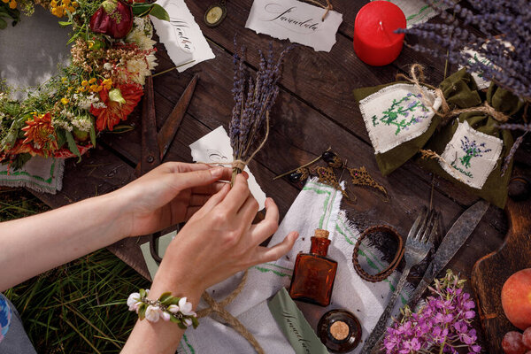 Still life on a wooden table. Lavender seeds, buds and flowers - aromatherapy and herbal medicine. Festive table in nature. Solstice concept. Lettering.