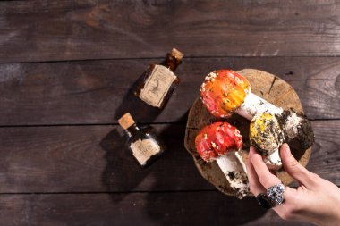 Büyücülük ve kara sanat kavramı. Ahşap zemin üzerinde zehirli madde ve mantar olan şişeler. Gizemli. Düz yatıyordu.