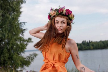 Kafasında çiçek çelengi olan Slav güzeli doğanın kucağında. Antik putperest kökenli kutlama konsepti. Yaz gündönümü günü. Yaz ortası.