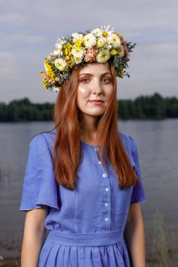 Kafasında çiçek çelengi olan Slav güzeli doğanın kucağında. Antik putperest kökenli kutlama konsepti. Yaz gündönümü günü. Yaz ortası.