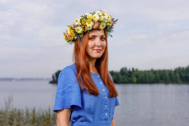 Kafasında çiçek çelengi olan Slav güzeli doğanın kucağında. Antik putperest kökenli kutlama konsepti. Yaz gündönümü günü. Yaz ortası.