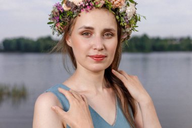 Kafasında çiçek çelengi olan Slav güzeli doğanın kucağında. Antik putperest kökenli kutlama konsepti. Yaz gündönümü günü. Yaz ortası.