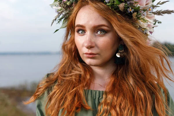 Kafasında çiçek çelengi olan Slav güzeli doğanın kucağında. Antik putperest kökenli kutlama konsepti. Yaz gündönümü günü. Yaz ortası.