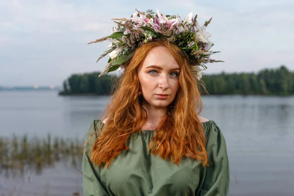 Kafasında çiçek çelengi olan Slav güzeli doğanın kucağında. Antik putperest kökenli kutlama konsepti. Yaz gündönümü günü. Yaz ortası.