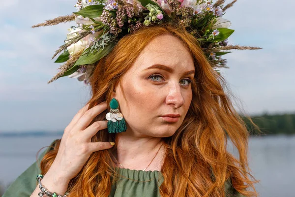 Kafasında çiçek çelengi olan Slav güzeli doğanın kucağında. Antik putperest kökenli kutlama konsepti. Yaz gündönümü günü. Yaz ortası.