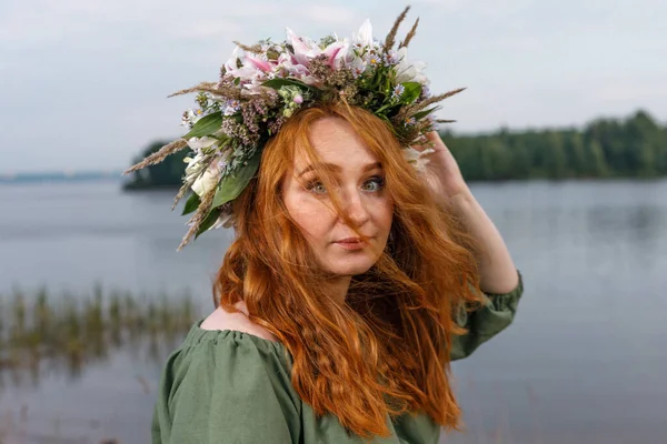Kafasında çiçek çelengi olan Slav güzeli doğanın kucağında. Antik putperest kökenli kutlama konsepti. Yaz gündönümü günü. Yaz ortası.