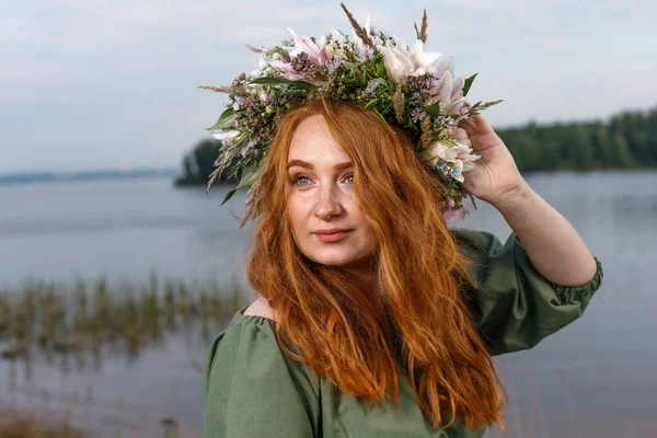 Kafasında çiçek çelengi olan Slav güzeli doğanın kucağında. Antik putperest kökenli kutlama konsepti. Yaz gündönümü günü. Yaz ortası.