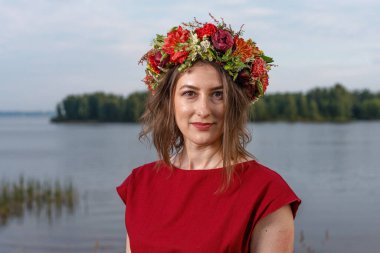 Kafasında çiçek çelengi olan Slav güzeli doğanın kucağında. Antik putperest kökenli kutlama konsepti. Yaz gündönümü günü. Yaz ortası.