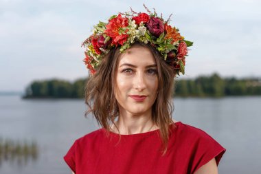 Kafasında çiçek çelengi olan Slav güzeli doğanın kucağında. Antik putperest kökenli kutlama konsepti. Yaz gündönümü günü. Yaz ortası.