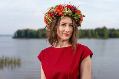 Kafasında çiçek çelengi olan Slav güzeli doğanın kucağında. Antik putperest kökenli kutlama konsepti. Yaz gündönümü günü. Yaz ortası.