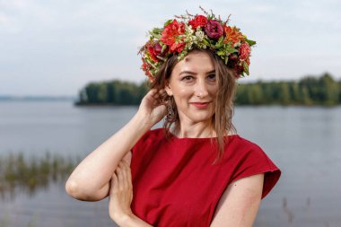 Kafasında çiçek çelengi olan Slav güzeli doğanın kucağında. Antik putperest kökenli kutlama konsepti. Yaz gündönümü günü. Yaz ortası.