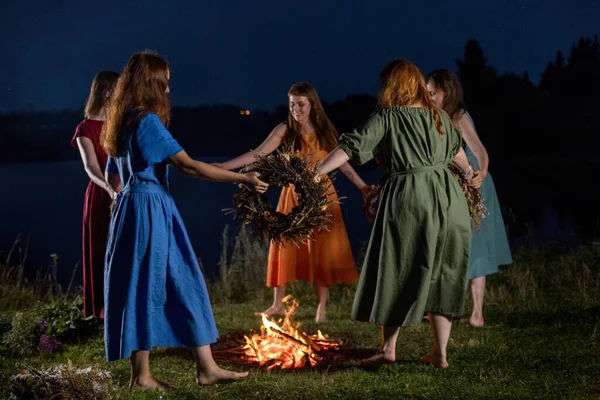 Geceleri şöminenin yanında güzel kızlar. Antik putperest kökenli kutlama konsepti. Ivan Kupala 'nın Gecesi.